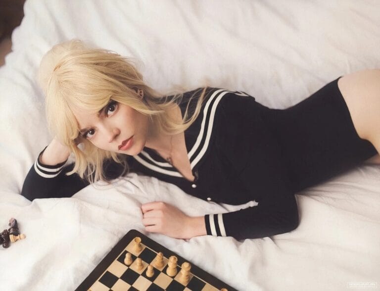 Anya Taylor-Joy: Wears a black bodysuit with white details, lying on a bed with sheets…