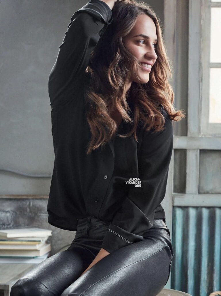 Alicia Vikander: Wears a relaxed-fit black shirt with white details, paired with pants…