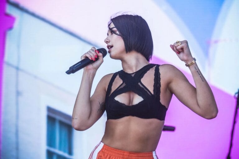 Dua Lipa: Luce un top negro de encaje con cortes audaces que realza su figura, combinado…