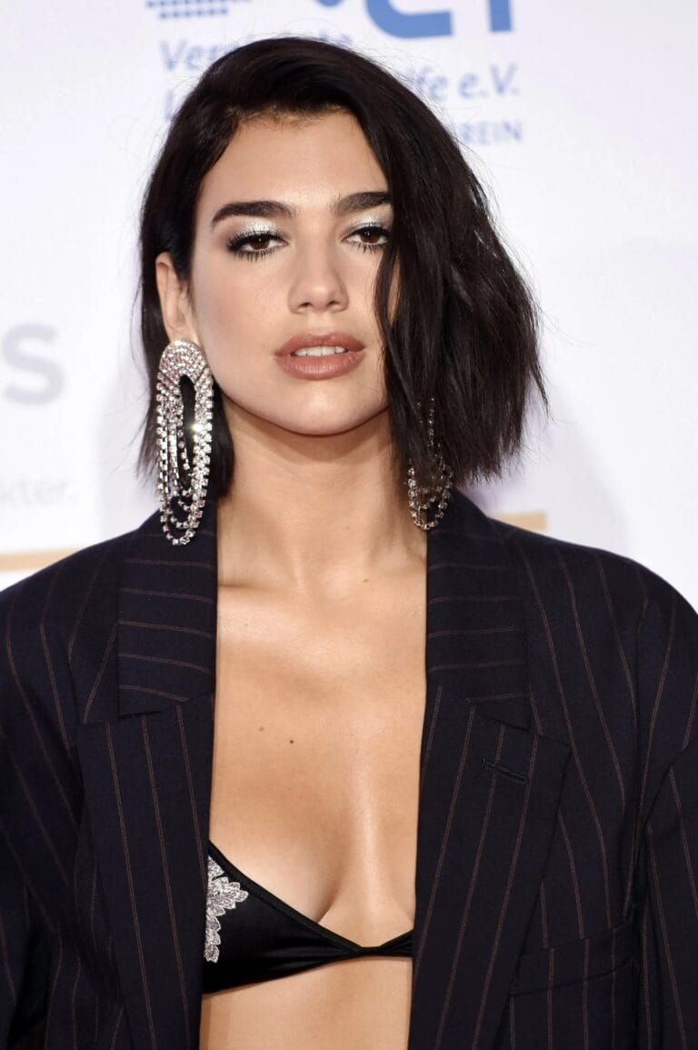 Dua Lipa: Luce un blazer a rayas oscuro que cae con elegancia sobre un sujetador negro…