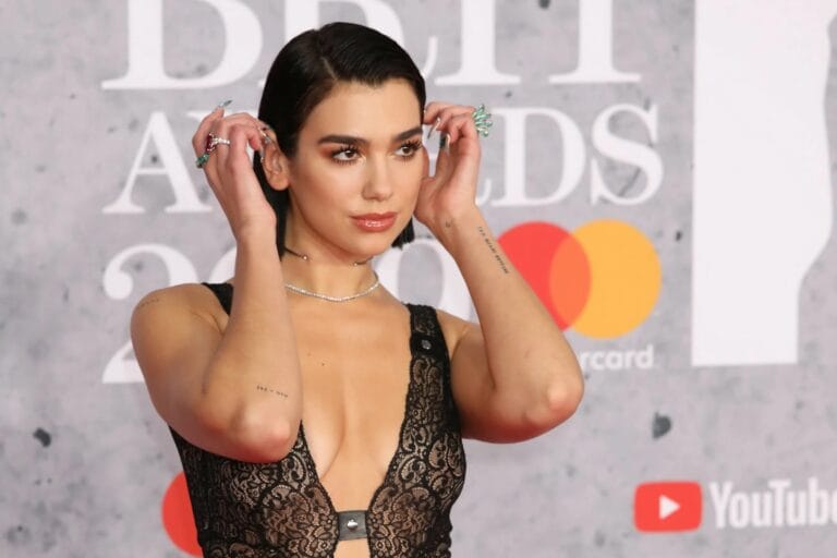 Dua Lipa: Luce un vestido de encaje negro con un profundo escote, acentuando su figura de…
