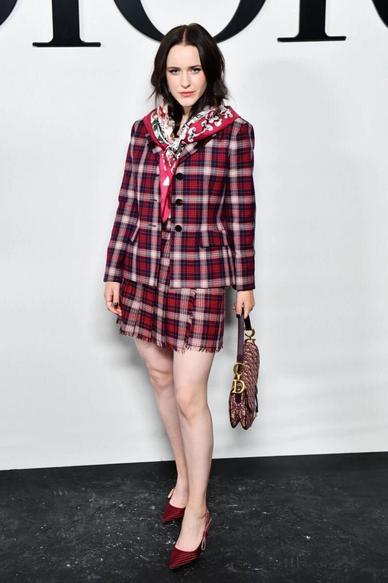 Rachel Brosnahan: Wears a red plaid jacket and mini skirt set, with…