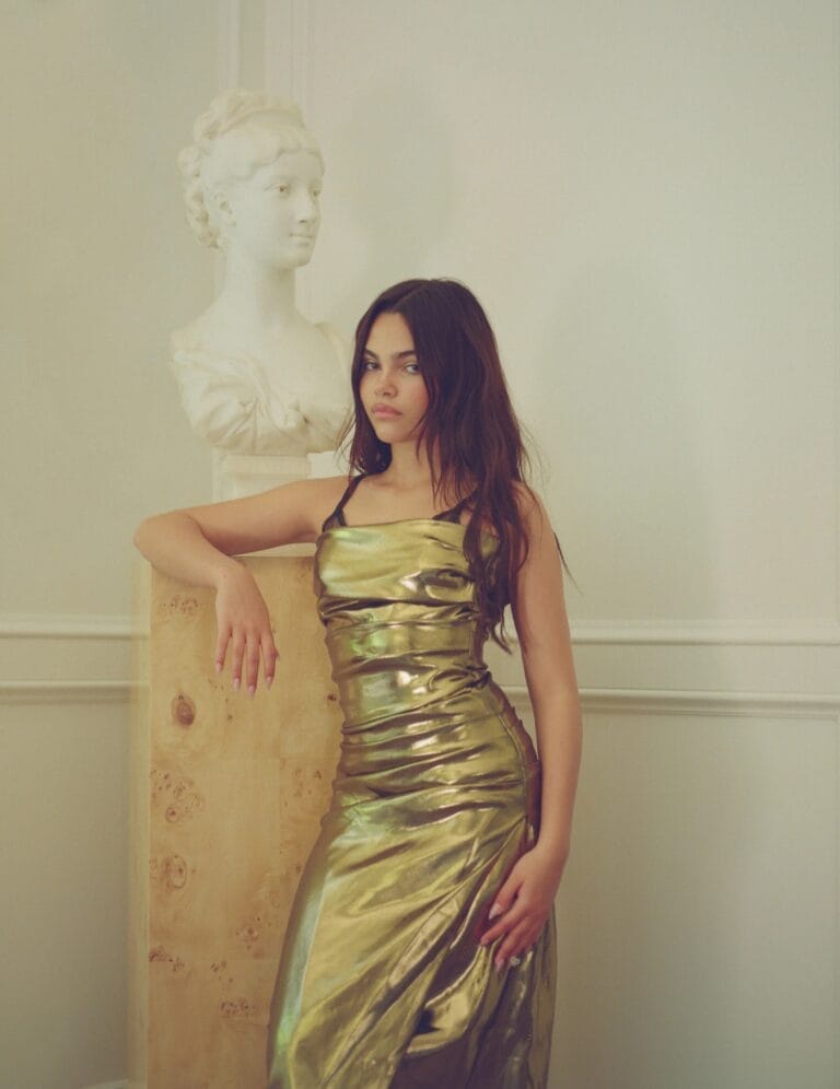 Ariana Greenblatt: Wears a metallic gold dress, fitted and with an asymmetric cut that highlights her…
