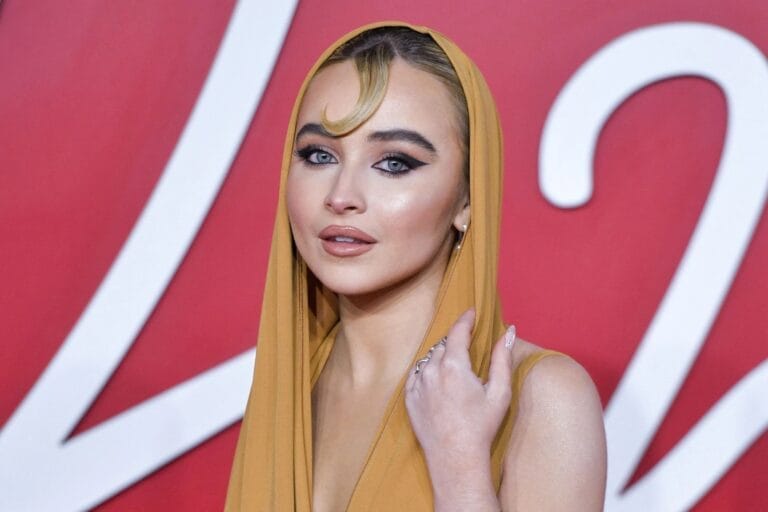 Sabrina Carpenter: Luce un vestido dorado con un elegante tocado que enmarca su rostro, mientras posa…