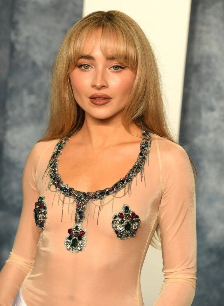 Sabrina Carpenter: Luce un top transparente de manga larga con un elaborado collar de joyas que…