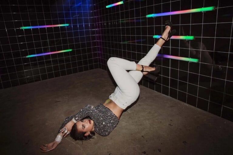 Dua Lipa: Posa en el suelo con una actitud audaz, vistiendo un top brillante de lentejuelas…