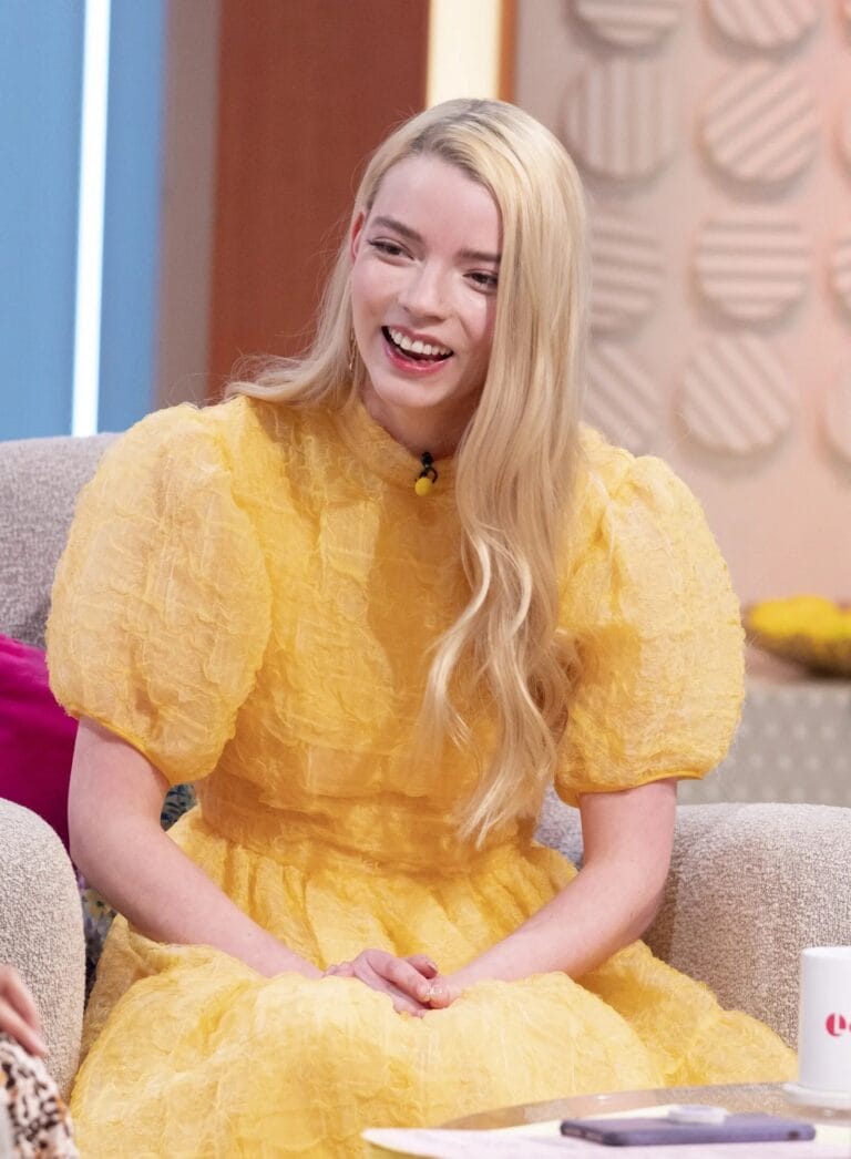 Anya Taylor-Joy: Luce un vestido amarillo con mangas abullonadas, que resalta su figura mientras se sienta…