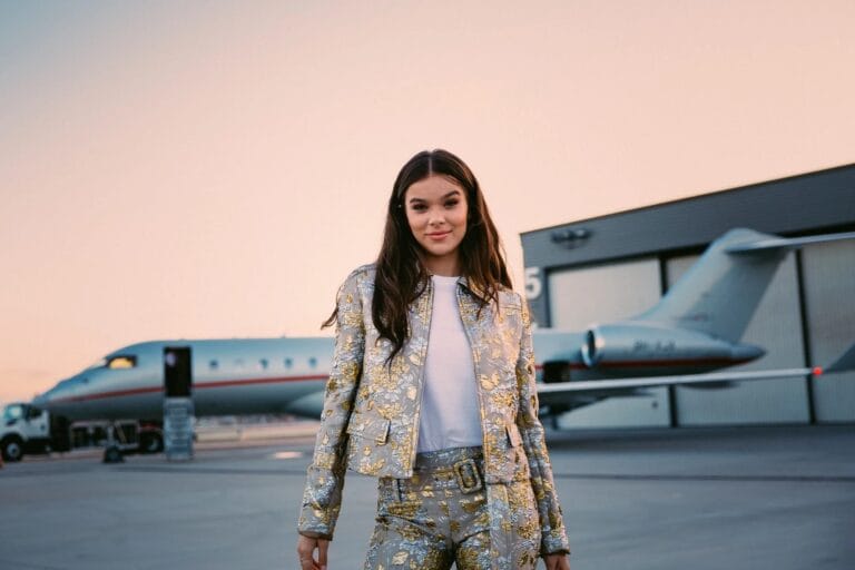 Hailee Steinfeld: Luce un conjunto plateado con detalles florales dorados, combinando una chaqueta corta con pantalones…