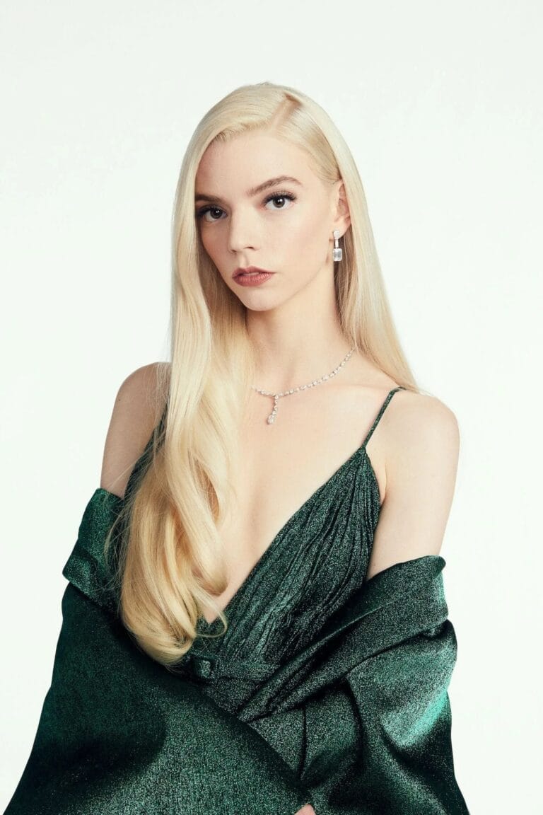 Anya Taylor-Joy: Luce un vestido verde oscuro con un escote profundo y detalles plisados, mientras sostiene…