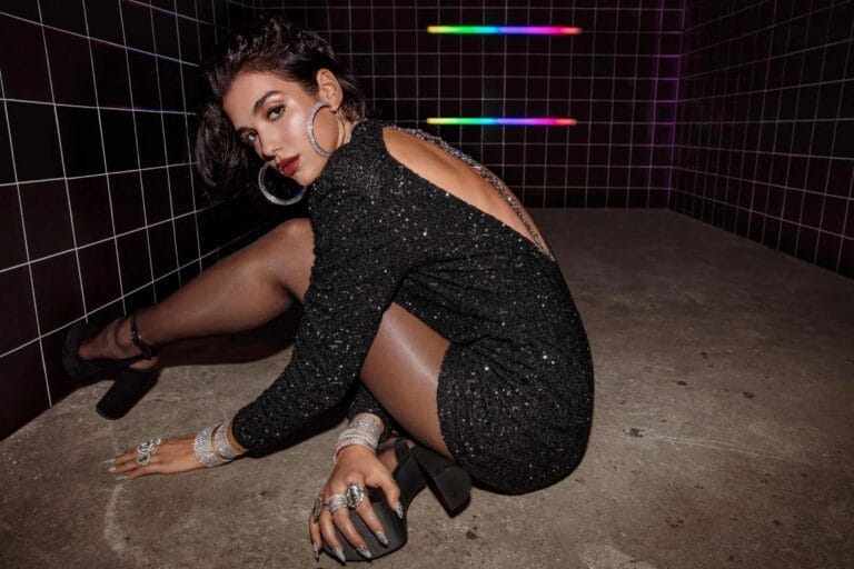 Dua Lipa: Posa en el suelo, con un vestido negro de lentejuelas que resalta su figura…