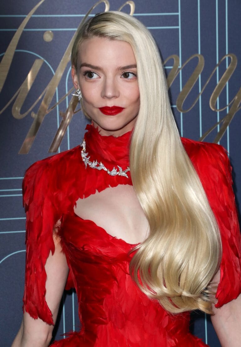 Anya Taylor-Joy: Wears a vibrant red dress with feather details that highlight her silhouette, standing out…