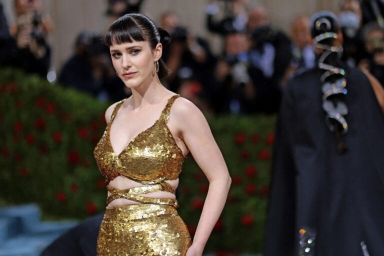 Rachel Brosnahan: Wears a shiny gold dress with sequin details that highlights her figure with…