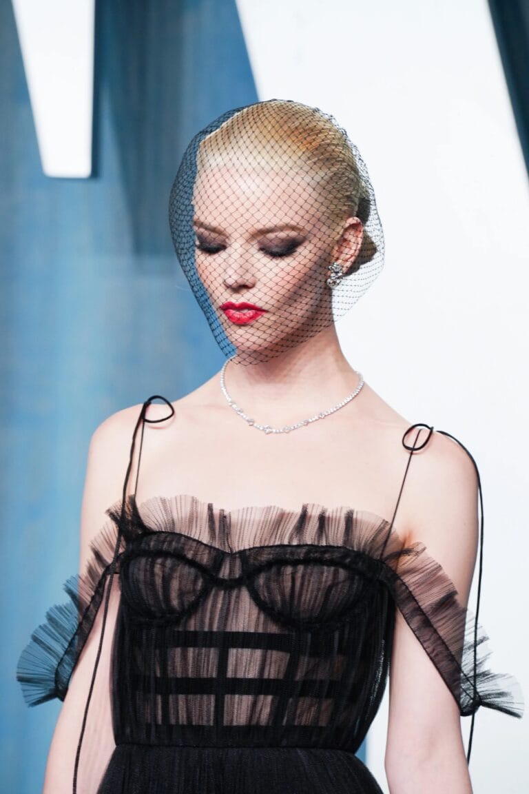 Anya Taylor-Joy: Wears a black sheer tulle dress with ruffle details that highlights her…