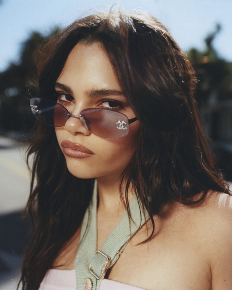 Ariana Greenblatt: Wears a pink top that highlights her figure, paired with sunglasses…
