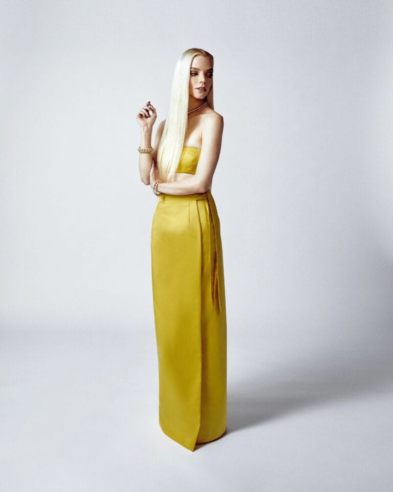 Anya Taylor-Joy: Wears a long, yellow, sleeveless, fitted dress that highlights her slender figure.…