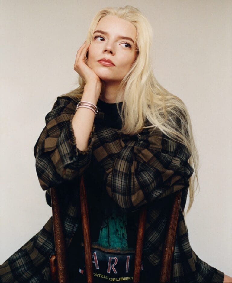 Anya Taylor-Joy: Wears a brown plaid shirt over a black T-shirt with a…