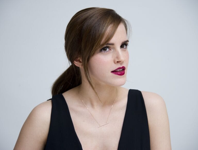 Emma Watson: Luce un elegante top negro con escote, que resalta su figura. Complementa el look…
