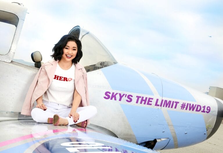 Lana Condor: Wears a white T-shirt with the word "HERO" in red, paired with white pants…
