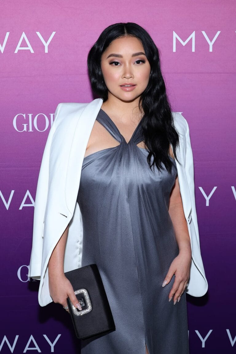 Lana Condor: Luce un sofisticado vestido gris con un drapeado elegante que destaca su figura, complementado…