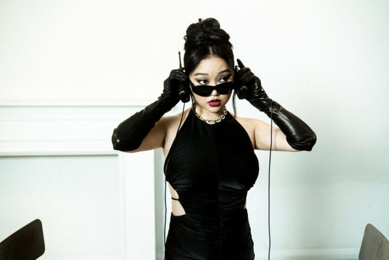 Lana Condor: Wears a fitted black dress with side cutouts that highlights her figure with a…