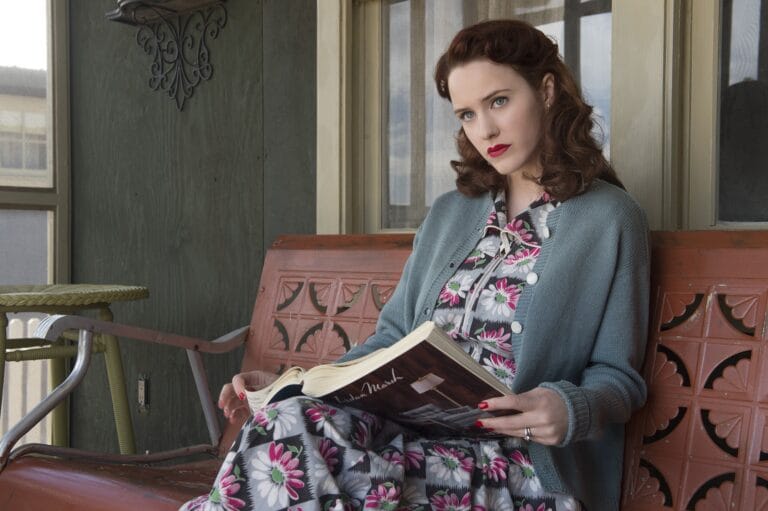 Rachel Brosnahan: Wears a dark floral-print dress, paired with a sweater of…