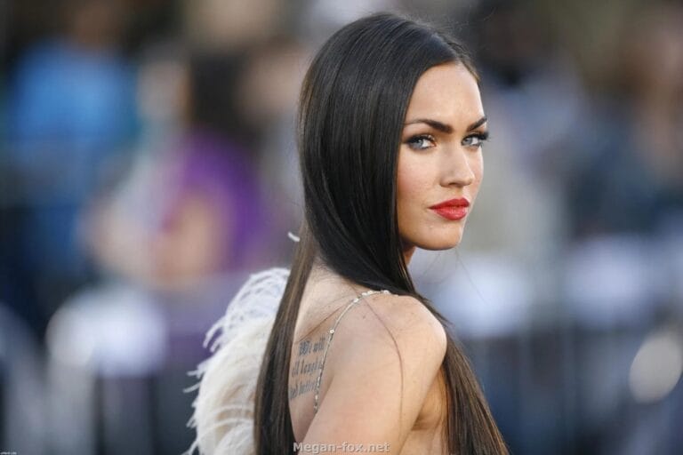 Megan Fox: Wears an elegant dress with thin straps and feather details on the shoulder,…