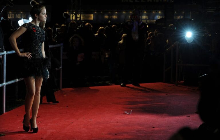 Emma Watson: Wears a black lace dress with feather details at the hem,…