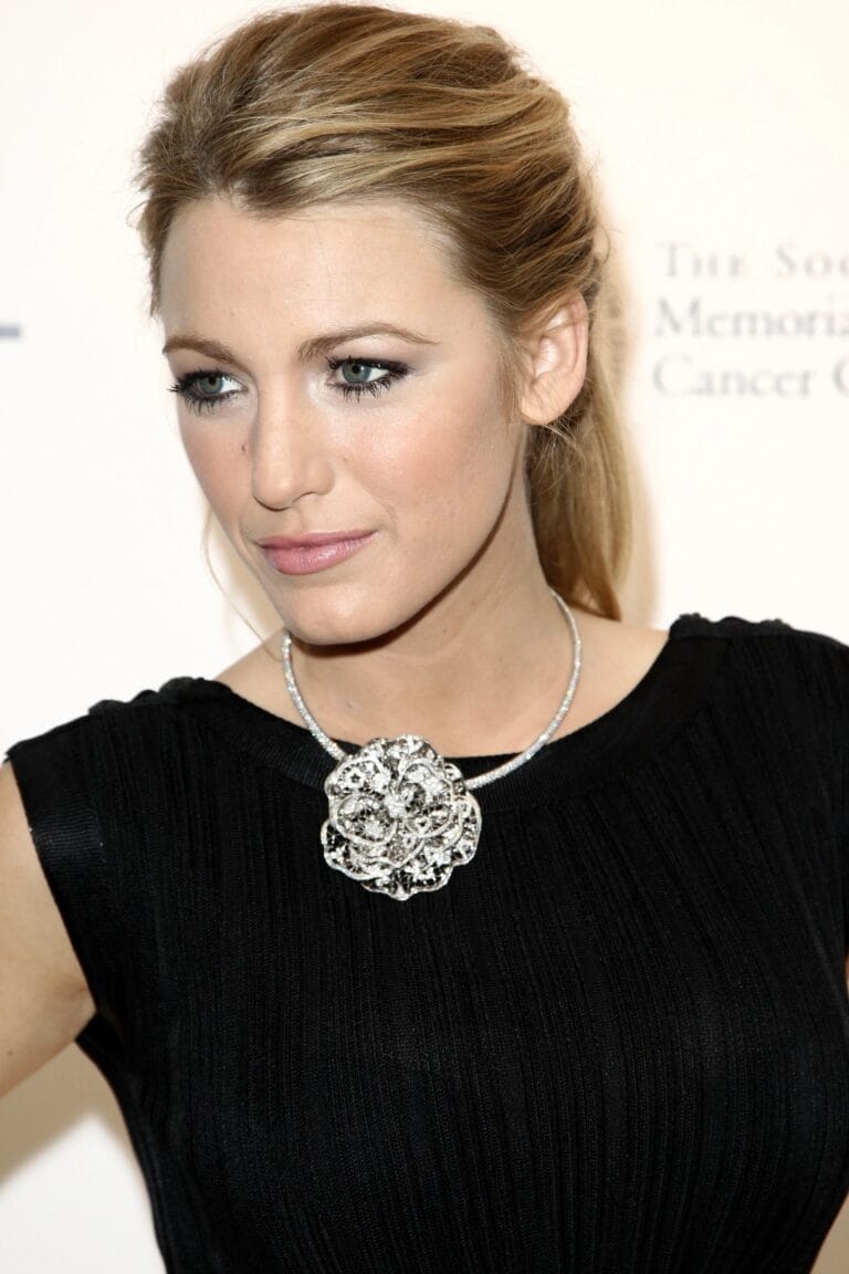 Blake Lively: Wears an elegant black dress with a subtle pleated design that highlights her figure.…