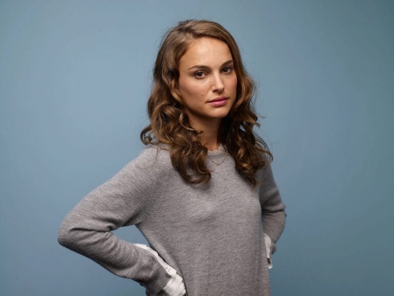 Natalie Portman: Wears an oversized gray sweater with slightly flared sleeves while holding…