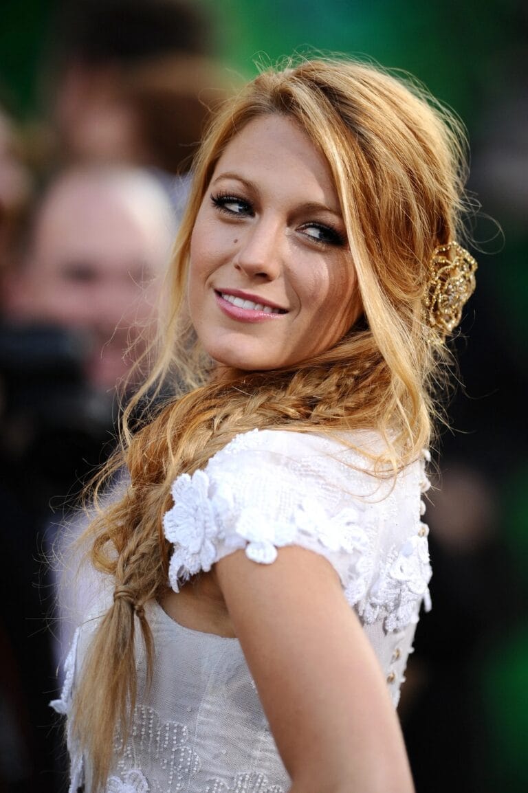 Blake Lively: Wears a white dress with lace details on the sleeves, while her hair…