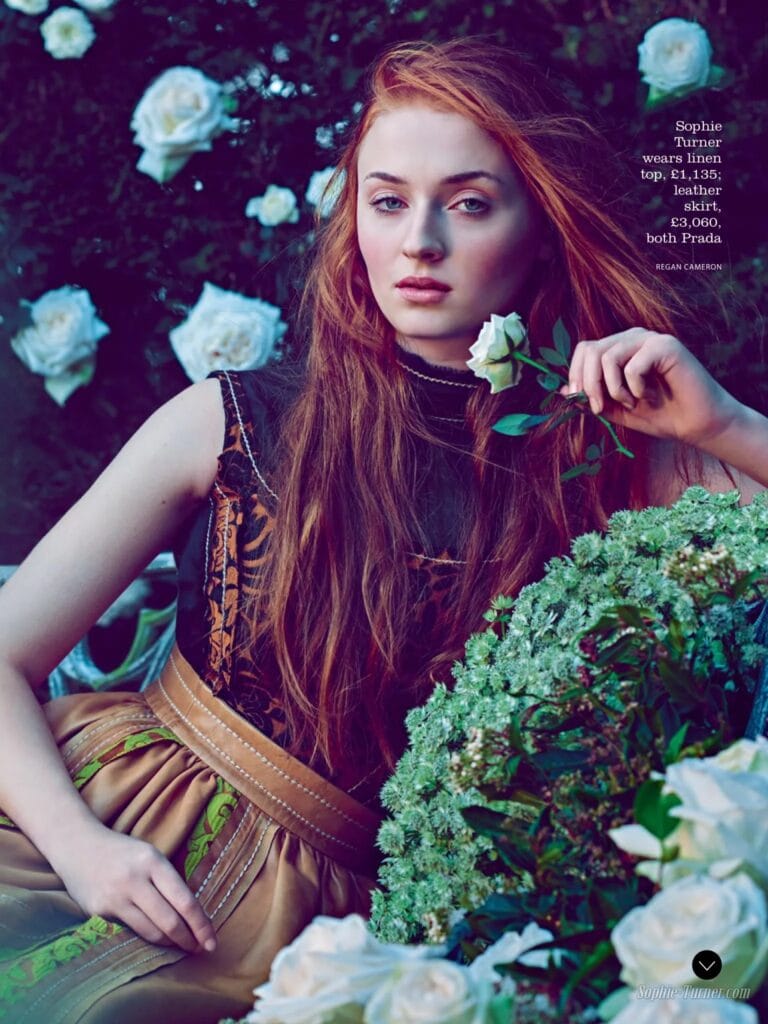 Sophie Turner: Wears a black linen top with a warm-toned print and a skirt…