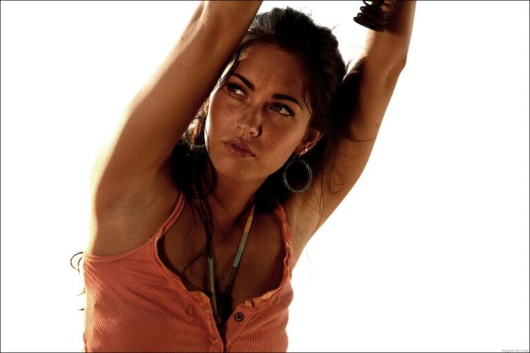 Megan Fox: Wears a peach-colored sleeveless top with a subtle neckline that adds…