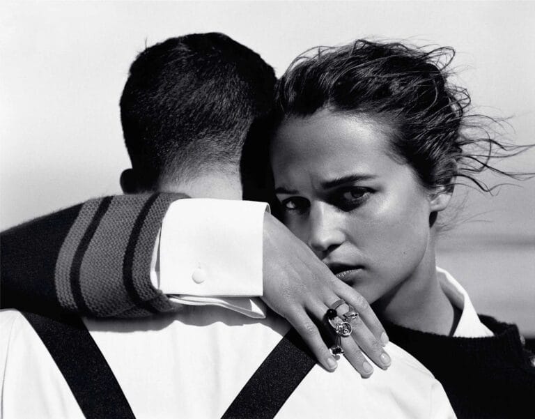 Alicia Vikander: Wearing a black sweater with a modern cut, while her hand is adorned with a ring&hellip;
