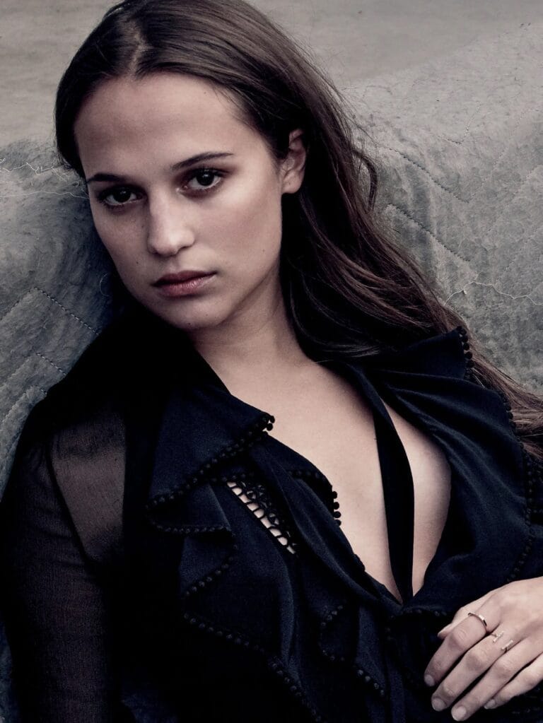 Alicia Vikander: Wears a black blouse with lace details and a plunging neckline, while she…