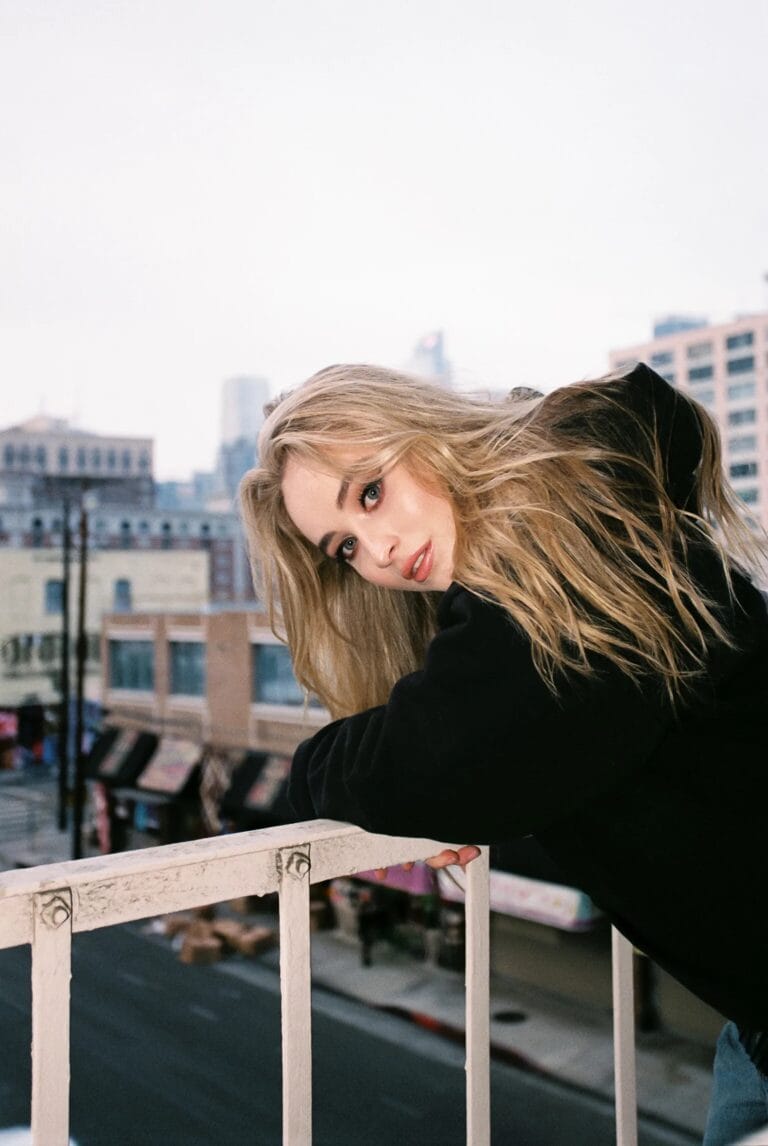 Sabrina Carpenter: Luce una sudadera negra, apoyada en una barandilla con un aire relajado y casual.…