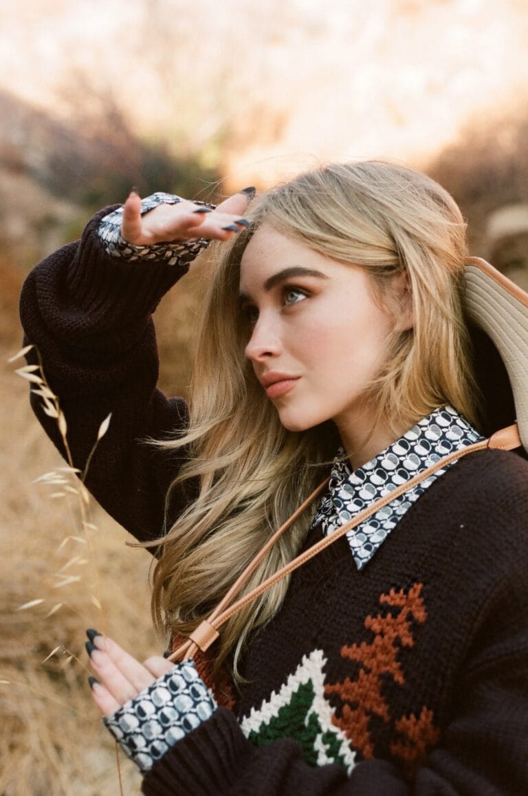 Sabrina Carpenter: Luce un suéter marrón con un diseño colorido en el pecho, complementado con una…