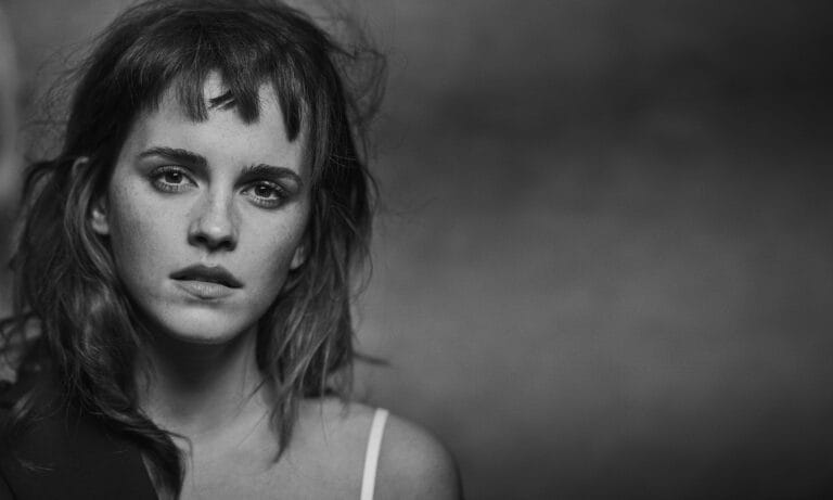 Emma Watson: Luce un top de tirantes en un ambiente de alto contraste, donde la luz…