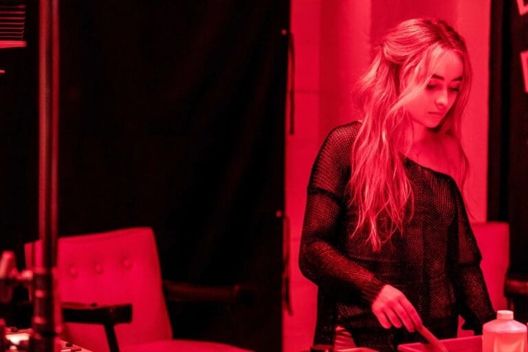 Sabrina Carpenter: Luce un top de malla negra con un hombro descubierto, sumergida en un ambiente…