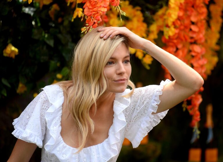 Sienna Miller: Wears a white dress with lace details and ruffled sleeves, while…