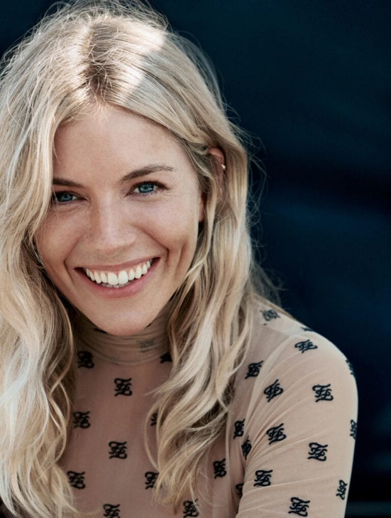 Sienna Miller: Wears a sheer blouse with a letter print, smiling broadly as her…