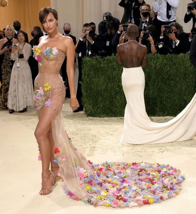 Irina Shayk: Wears a sheer dress with vibrant floral details, highlighting her figure…