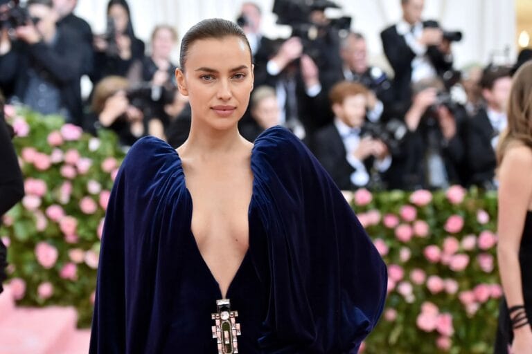Irina Shayk: Wears a stunning navy blue velvet dress with a deep neckline that accentuates…