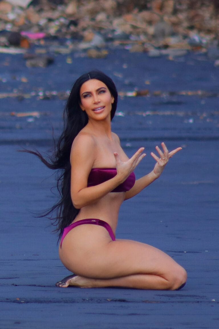 Kim Kardashian: Está en la playa, de rodillas sobre la arena oscura, luciendo un bikini morado…