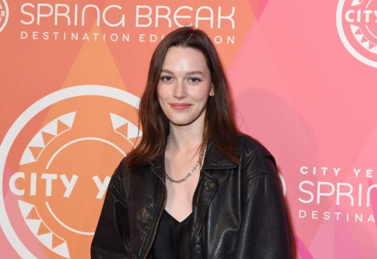Victoria Pedretti: Wears a black leather jacket over a black satin blouse, with a…
