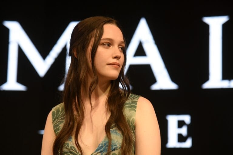 Victoria Pedretti: Wears a green dress with a leaf print that accentuates her figure with a…