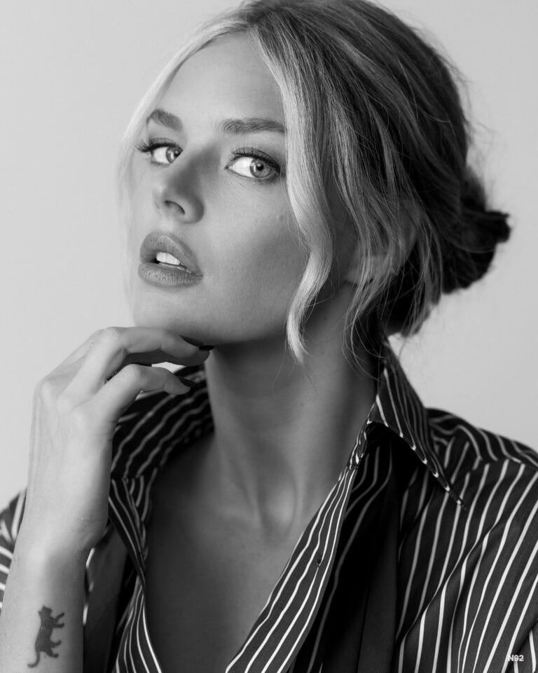 Samara Weaving: Wears a dark striped shirt with a loose cut while holding…