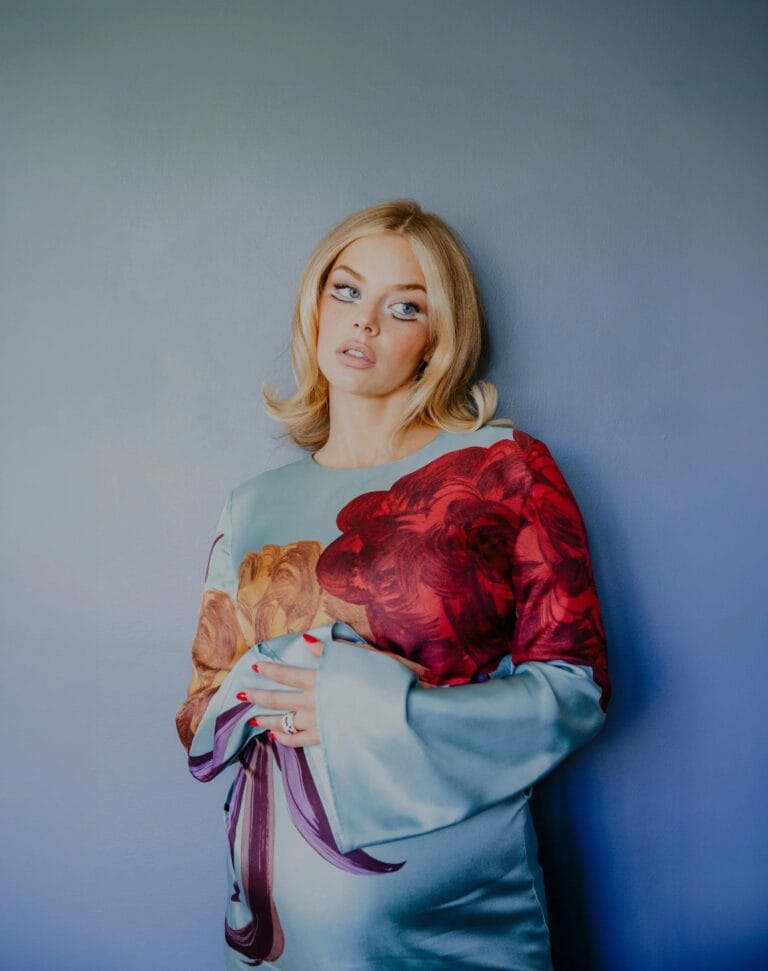 Samara Weaving: Wears a silk dress with a vibrant floral print in red tones…