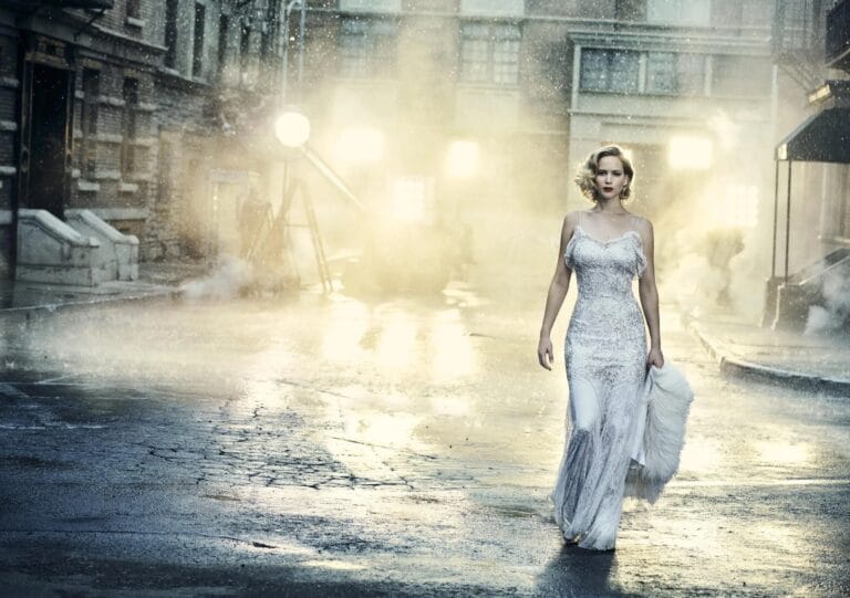 Jennifer Lawrence: Appears walking confidently through an elegant city in the rain, wearing a dress…