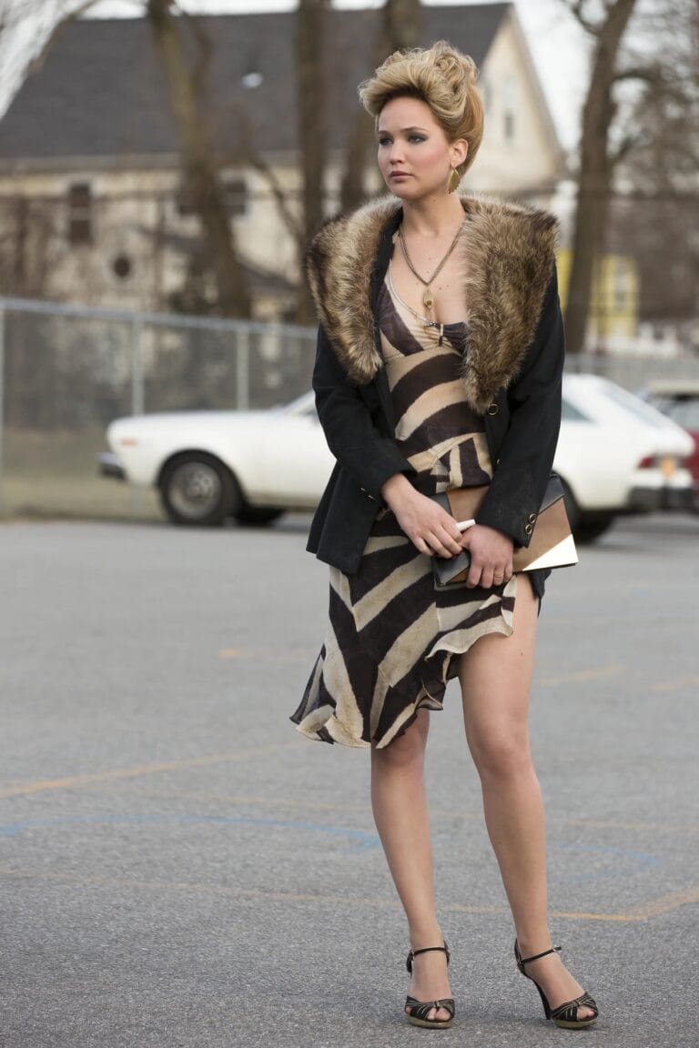 Jennifer Lawrence: Wears an asymmetric dress in a brown and black print, with a coat…