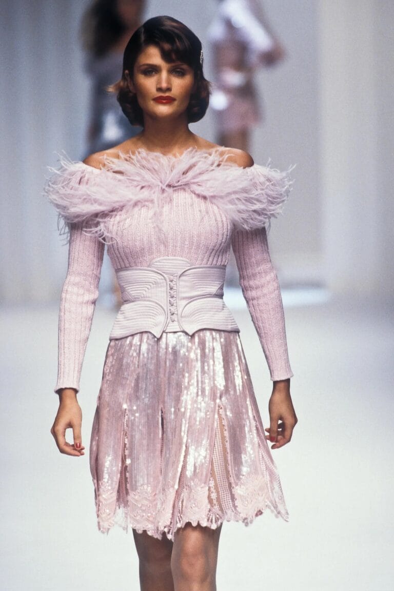 Helena Christensen: Wears a pink dress with feather details at the neckline and a skirt…
